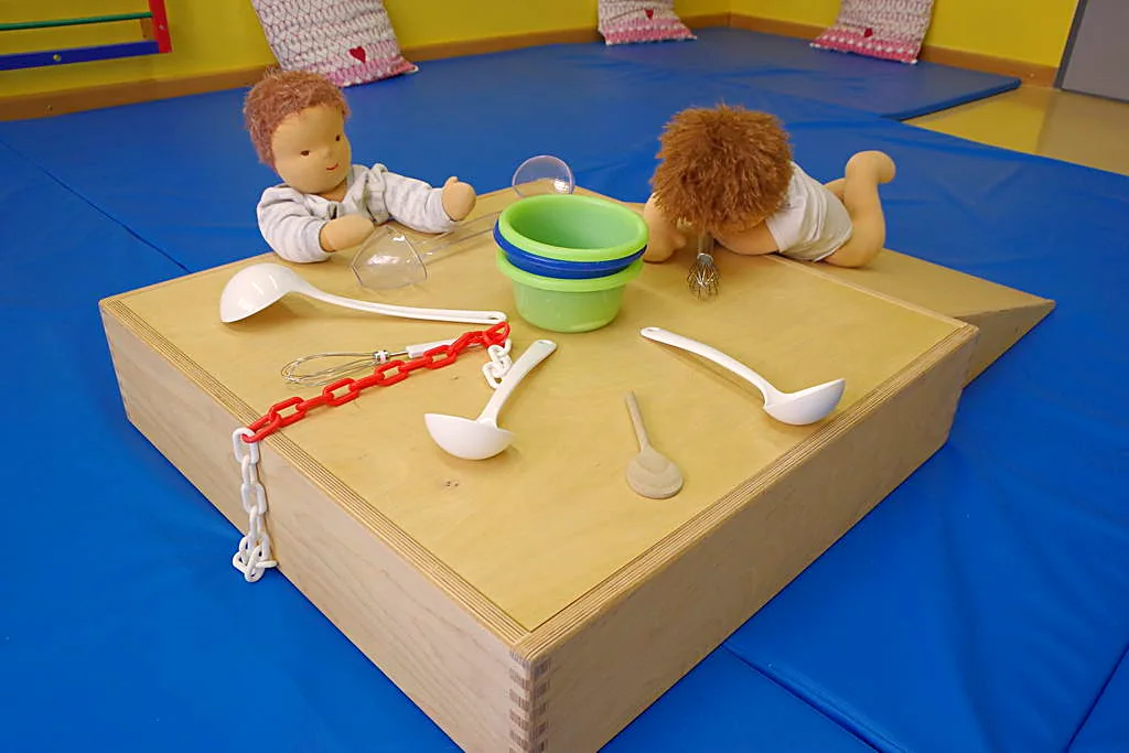 Puppen und Spielgeschirr auf einer Holzkiste