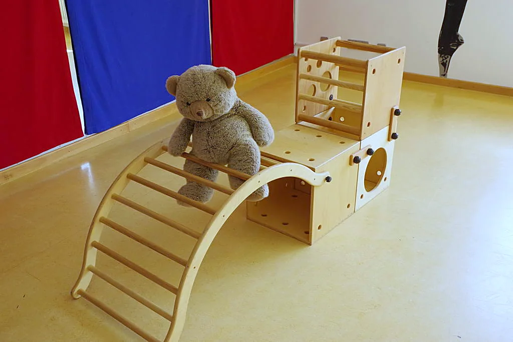 Teddy auf einem Kletterbogen aus Holz